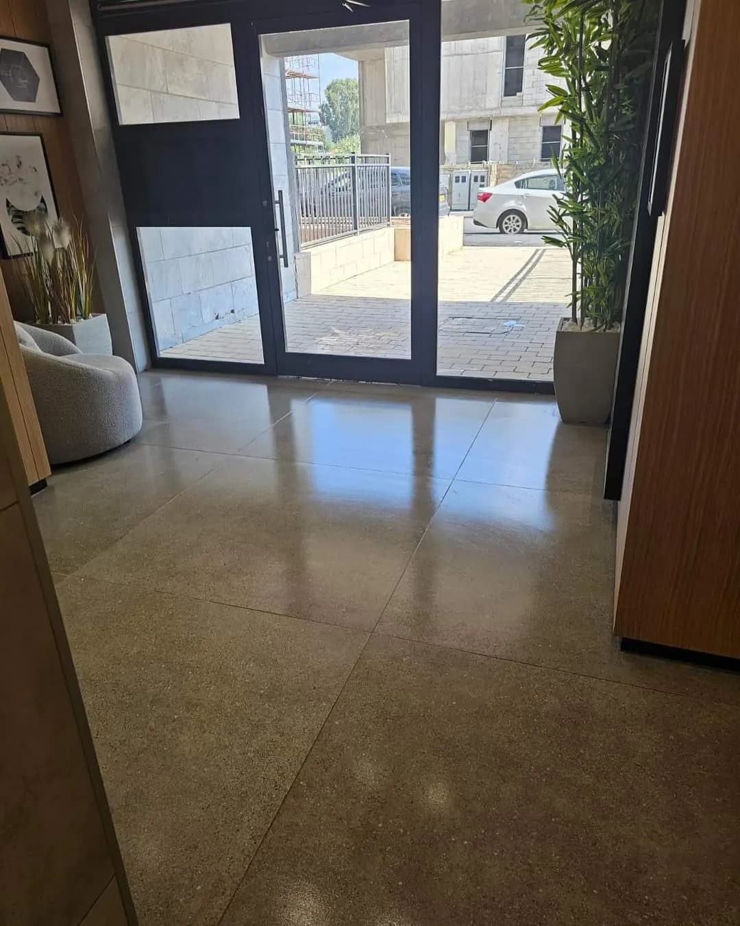 דלת כניסה מזכוכית ללובי של בניין מגורים בניהול אל ג׳י